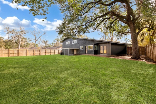 back of house featuring a yard and french doors