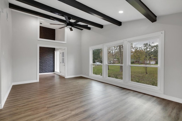 unfurnished living room featuring ceiling fan, wood-type flooring, and a wealth of natural light