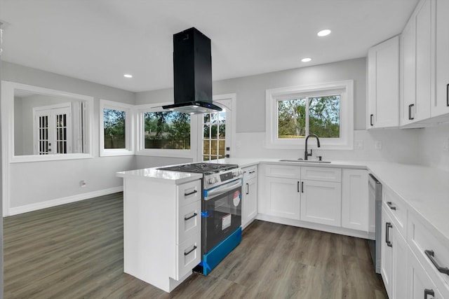 kitchen featuring appliances with stainless steel finishes, island range hood, sink, white cabinets, and dark hardwood / wood-style floors