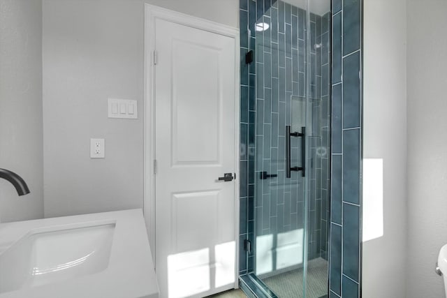 bathroom with a shower with door and sink