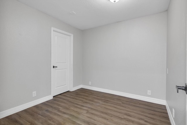 spare room featuring dark wood-type flooring