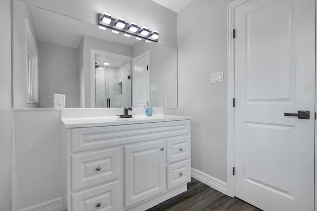 bathroom featuring vanity, hardwood / wood-style flooring, and a shower with door