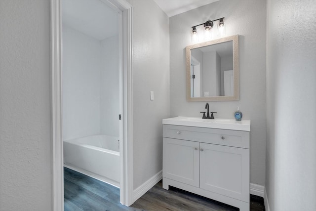 bathroom featuring a bathing tub, vanity, and wood-type flooring