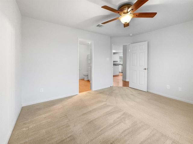 unfurnished bedroom with ceiling fan, light carpet, and ensuite bath