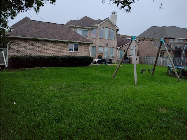 view of yard with a trampoline and a playground