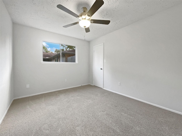 carpeted spare room featuring a textured ceiling and ceiling fan