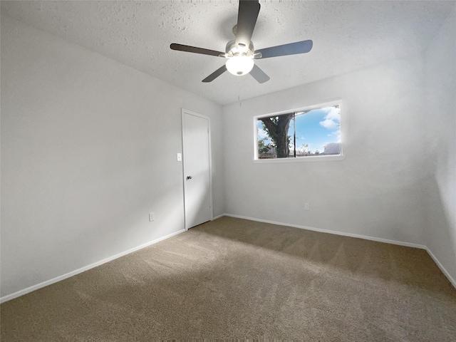 carpeted empty room featuring ceiling fan and a textured ceiling