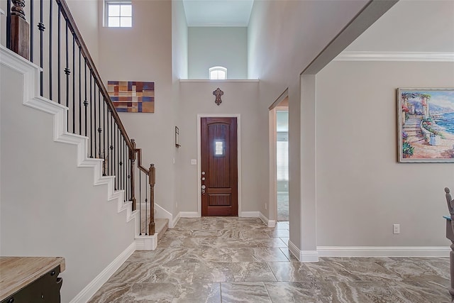 entrance foyer featuring a towering ceiling and ornamental molding