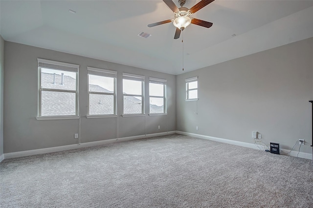 empty room with plenty of natural light, ceiling fan, and carpet floors