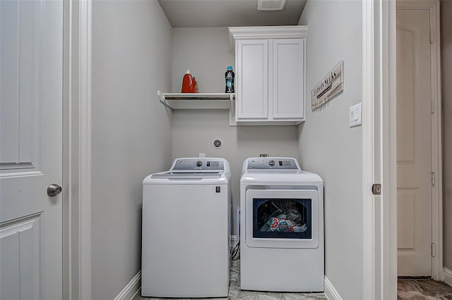 laundry room featuring washer and dryer and cabinets