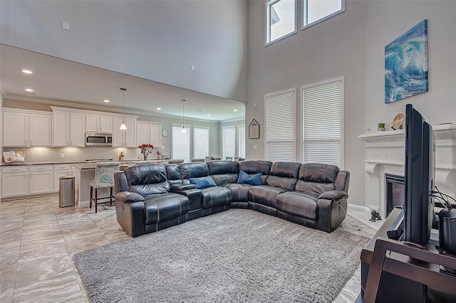 living room featuring a towering ceiling and ornamental molding