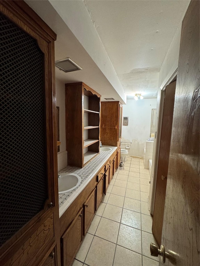 bathroom with vanity, a bidet, tile patterned flooring, toilet, and a tub