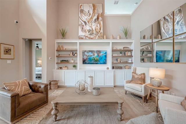 living room with a towering ceiling and ceiling fan