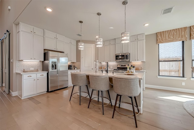 kitchen with decorative backsplash, white cabinetry, and stainless steel appliances