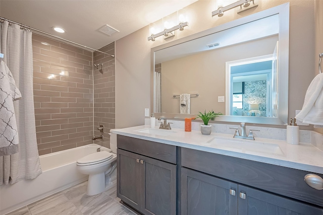 full bathroom featuring vanity, shower / tub combo, and toilet