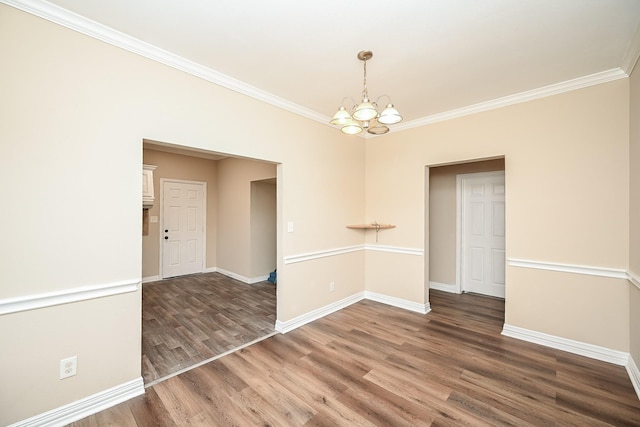 unfurnished room with a chandelier, crown molding, and dark wood-type flooring