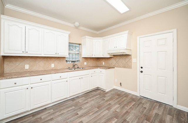 kitchen featuring crown molding, white cabinetry, sink, and light hardwood / wood-style floors