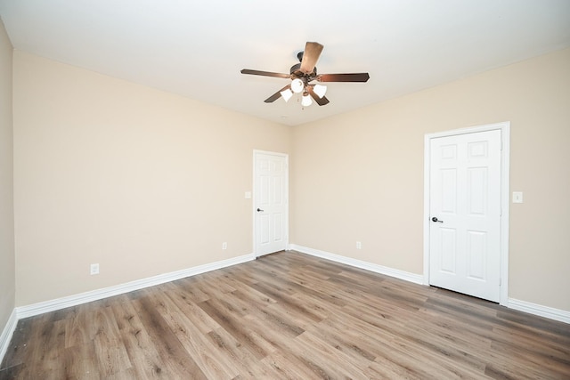 empty room with ceiling fan and light hardwood / wood-style flooring