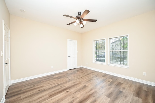 spare room featuring wood-type flooring and ceiling fan