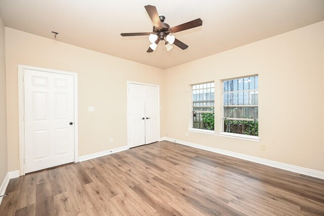 unfurnished bedroom featuring a closet, light hardwood / wood-style flooring, and ceiling fan