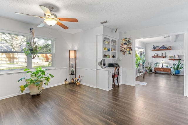 interior space featuring a textured ceiling, dark hardwood / wood-style flooring, and ceiling fan