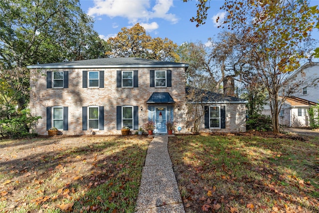 colonial-style house featuring a front yard