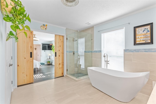 bathroom with separate shower and tub, tile walls, crown molding, and a textured ceiling