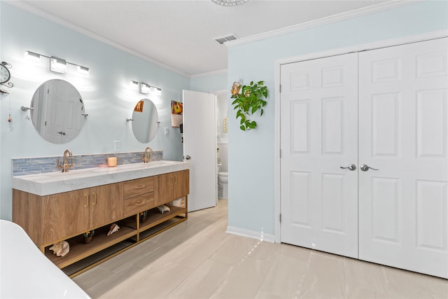 bathroom featuring vanity, toilet, and crown molding