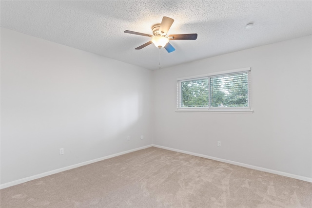 spare room featuring light carpet, ceiling fan, and a textured ceiling