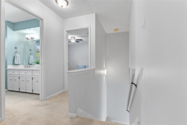 bathroom featuring ceiling fan, vanity, and a textured ceiling