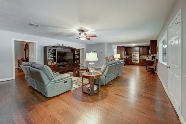 living room featuring ceiling fan and dark hardwood / wood-style flooring