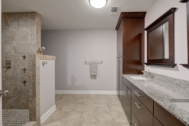 bathroom featuring vanity and tiled shower