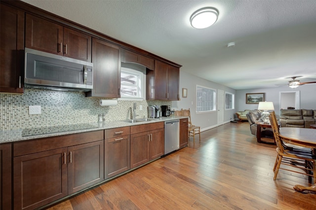 kitchen with dark brown cabinetry, sink, stainless steel appliances, and light hardwood / wood-style flooring