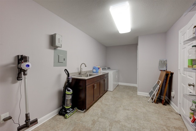 laundry area with cabinets, a textured ceiling, sink, separate washer and dryer, and electric panel