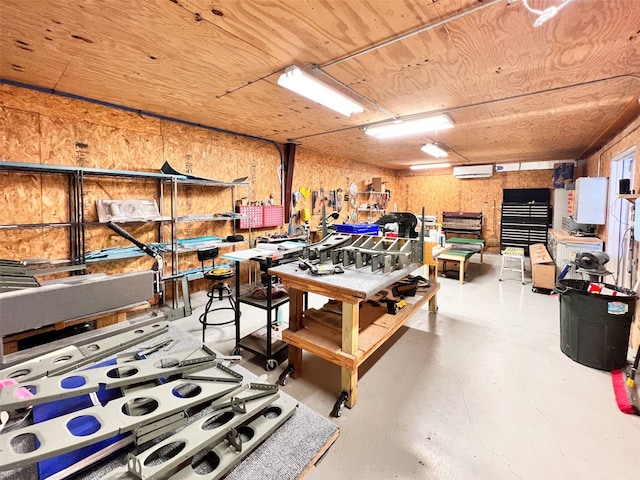 game room featuring a wall mounted air conditioner, concrete floors, a workshop area, and wood ceiling