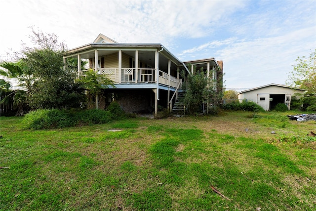 back of property with a yard, an outbuilding, and covered porch