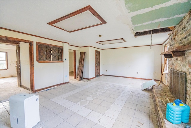 unfurnished living room featuring ornamental molding and a brick fireplace