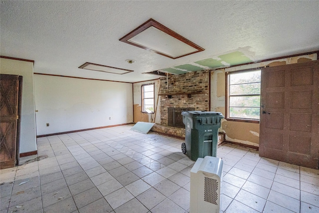 unfurnished living room featuring light tile patterned floors, a textured ceiling, and crown molding