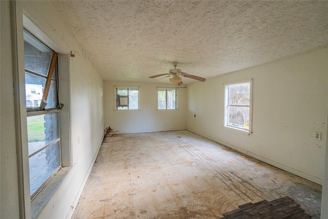 unfurnished room with ceiling fan and a textured ceiling