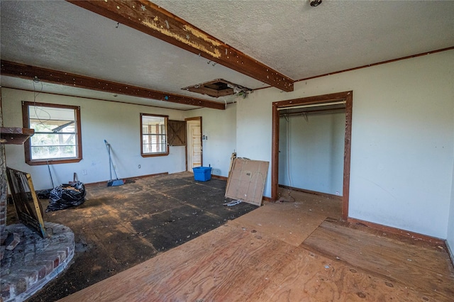 interior space featuring beam ceiling and a textured ceiling