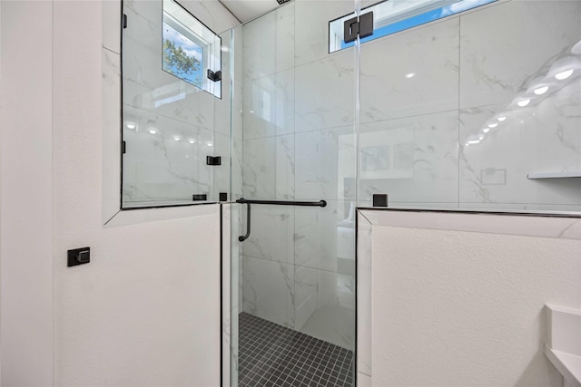 bathroom featuring a shower with shower door