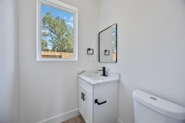 bathroom featuring hardwood / wood-style floors, vanity, and toilet