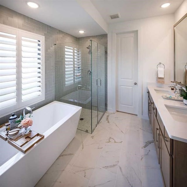 bathroom featuring vanity and separate shower and tub