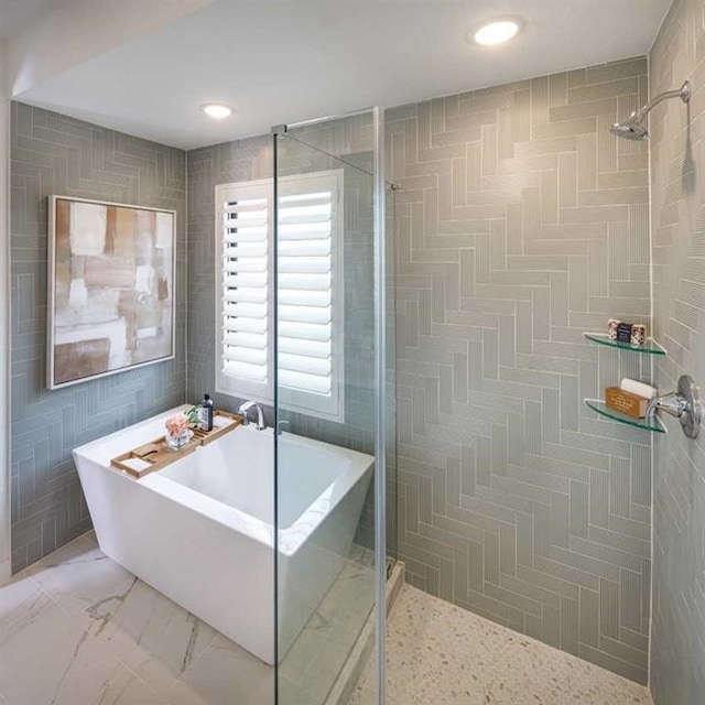 bathroom featuring plus walk in shower and tile walls