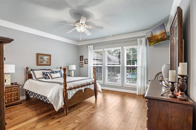 bedroom featuring ceiling fan, ornamental molding, and light wood-type flooring