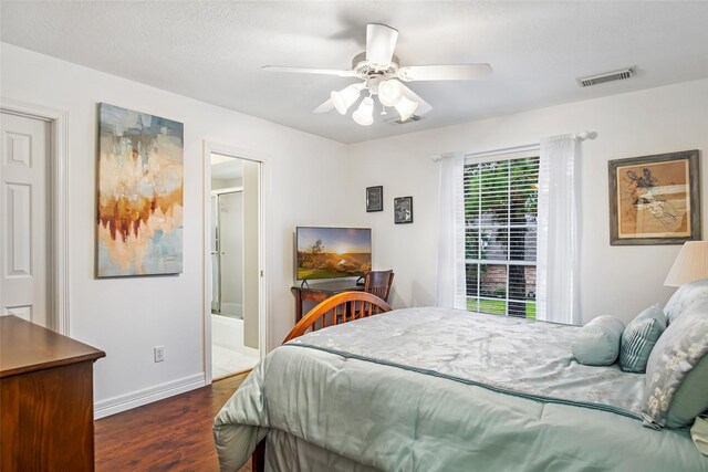 bedroom featuring connected bathroom, ceiling fan, and dark wood-type flooring