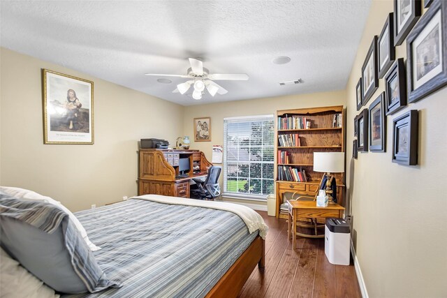 bedroom featuring a textured ceiling, ceiling fan, and dark hardwood / wood-style floors