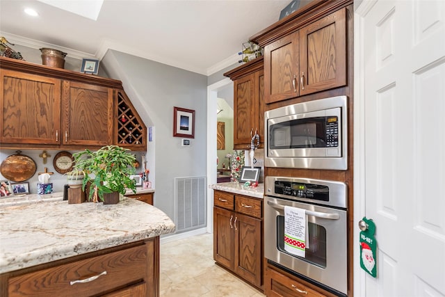 kitchen featuring stainless steel appliances, light stone counters, and crown molding