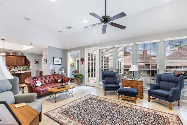 living room featuring ceiling fan, light tile patterned floors, and lofted ceiling