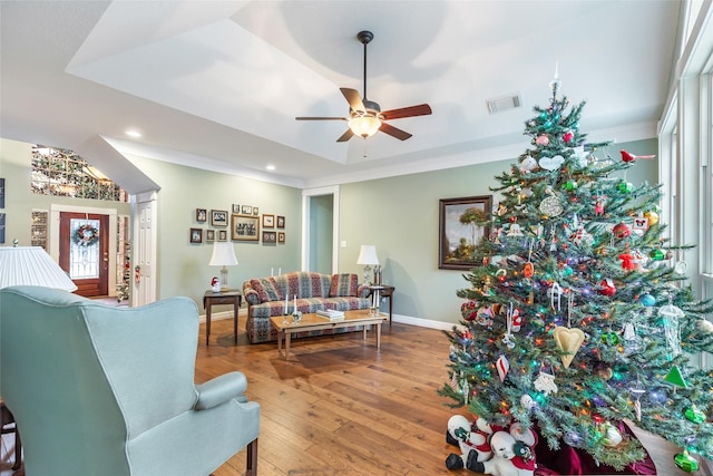 living room featuring ceiling fan, hardwood / wood-style floors, and crown molding